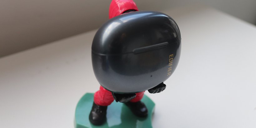 Edifier R1 earbuds being head by a Cable Guys Mini