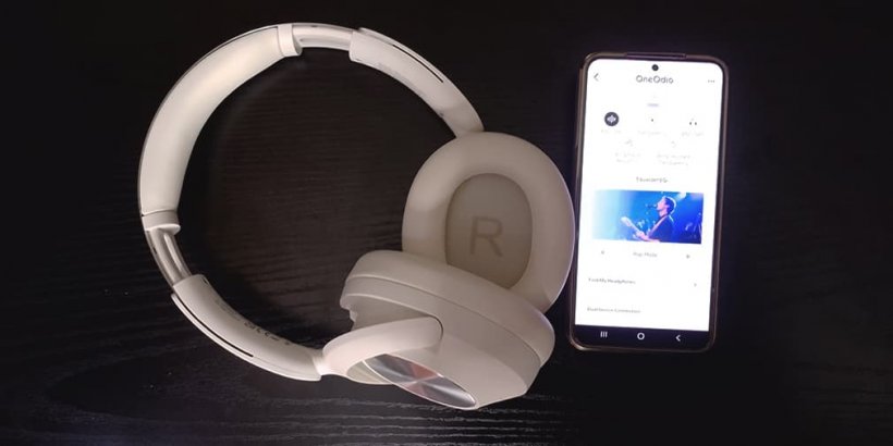 White OneOdio Focus A6 headphones next to phone with OneOdio app on screen